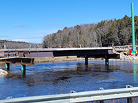 Looking north from George Wright Rd at work on temporary Pleasant Cove Bridge including installation of pre-cast deck slabs.